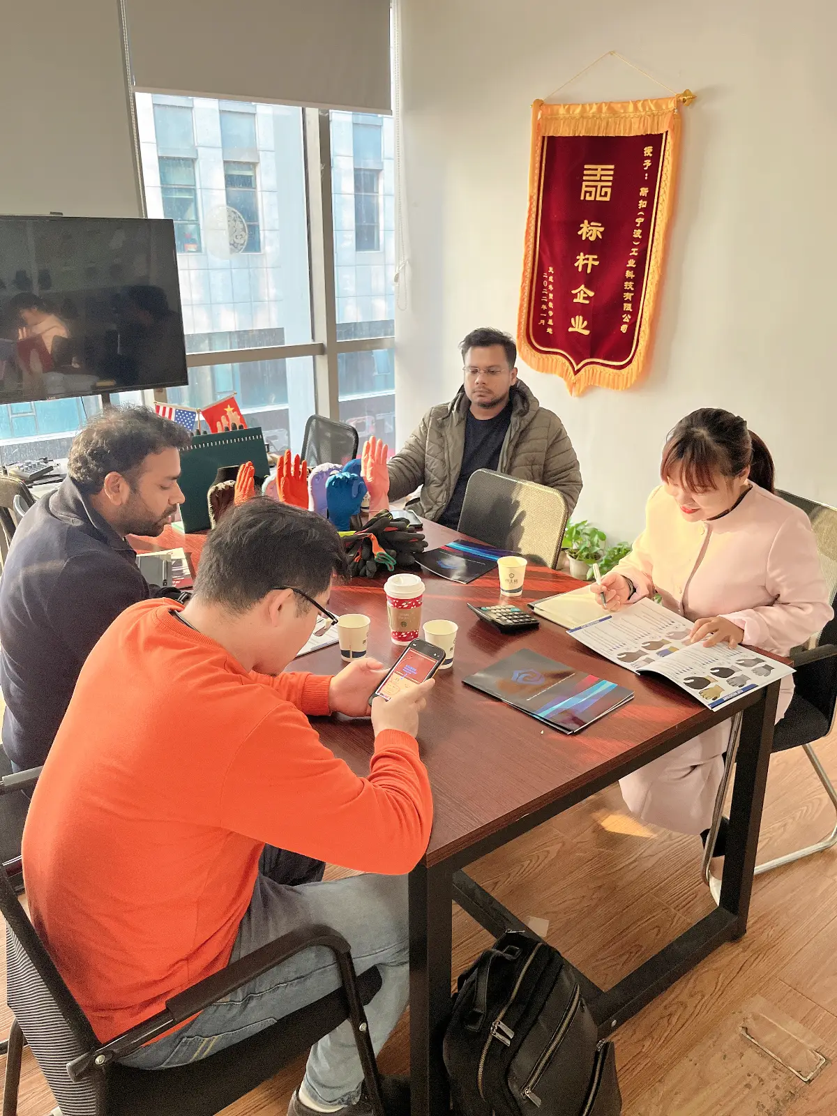 Business meeting reviewing glove samples and product catalogues