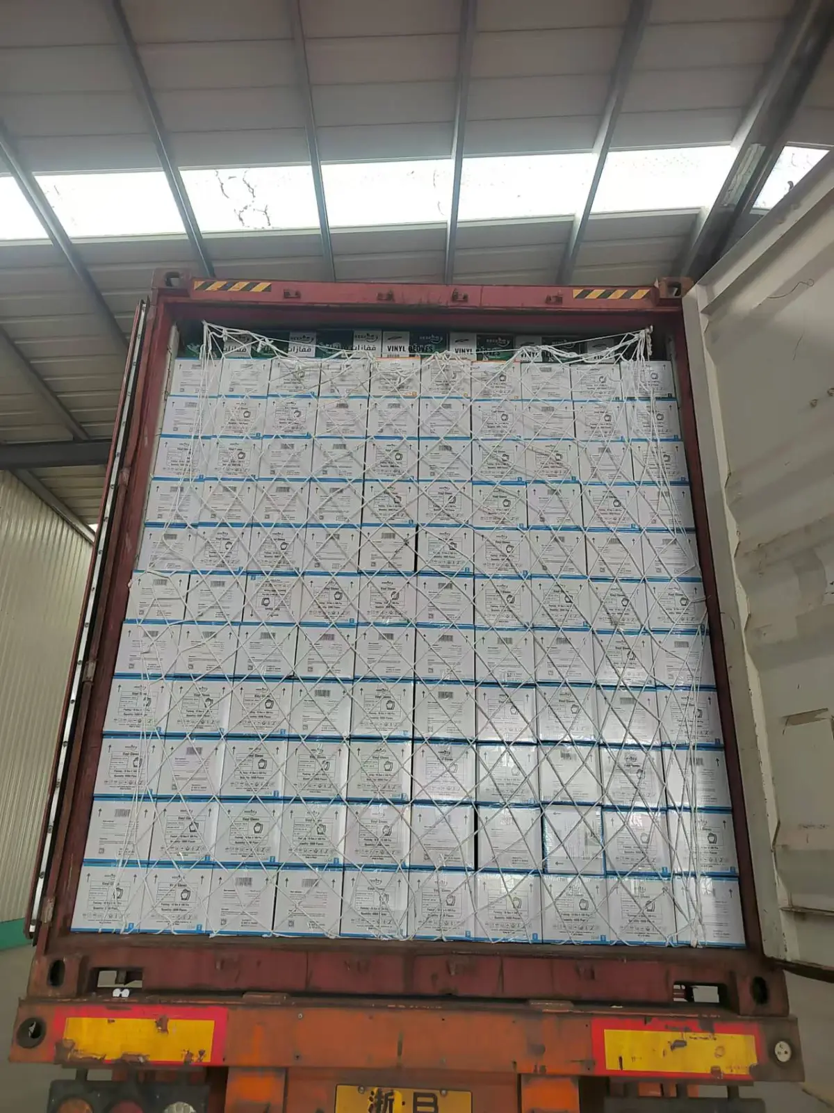 Vinyl glove cartons with cargo net inside a container